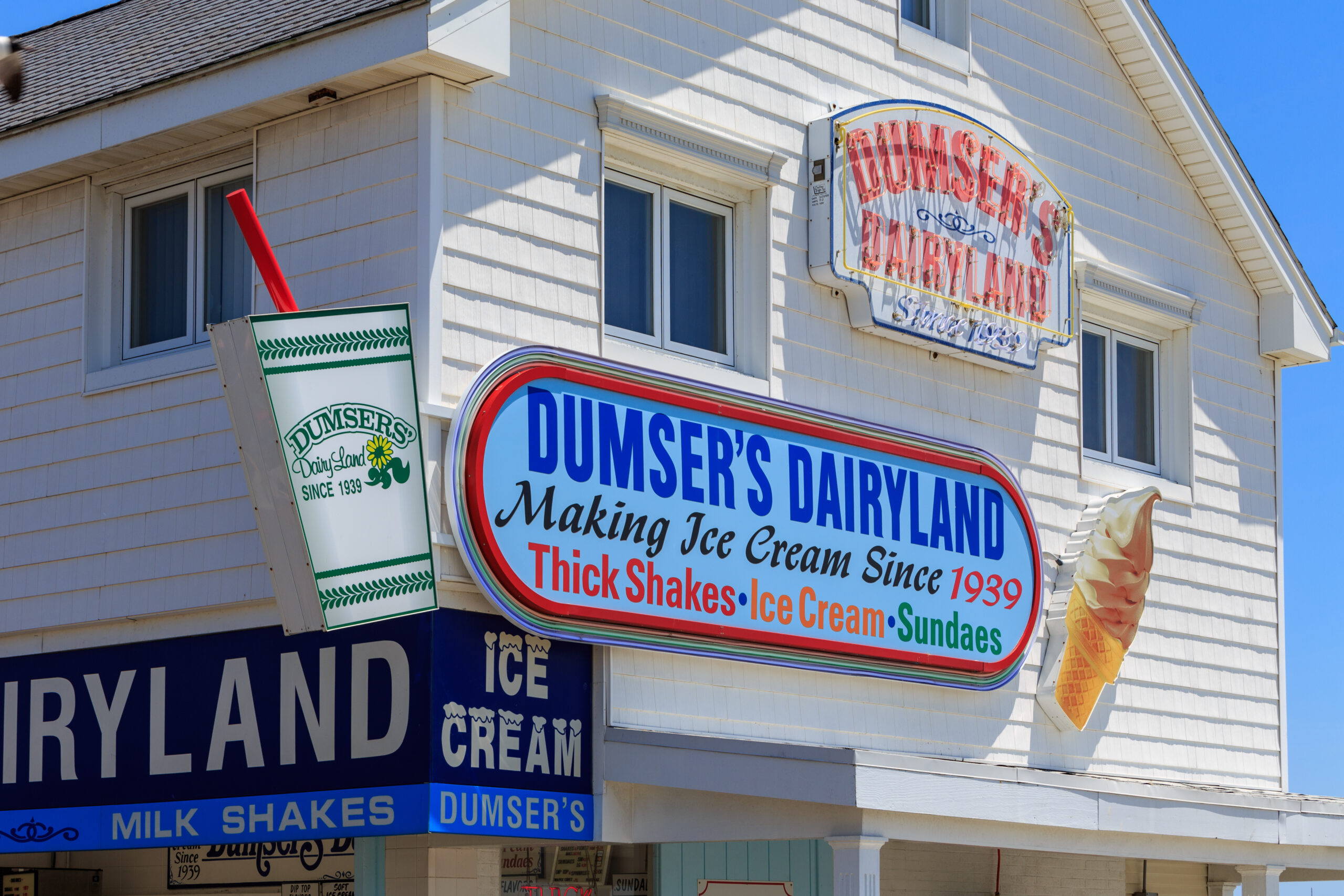 Sign that says Dumser's Dairyland on a white building.