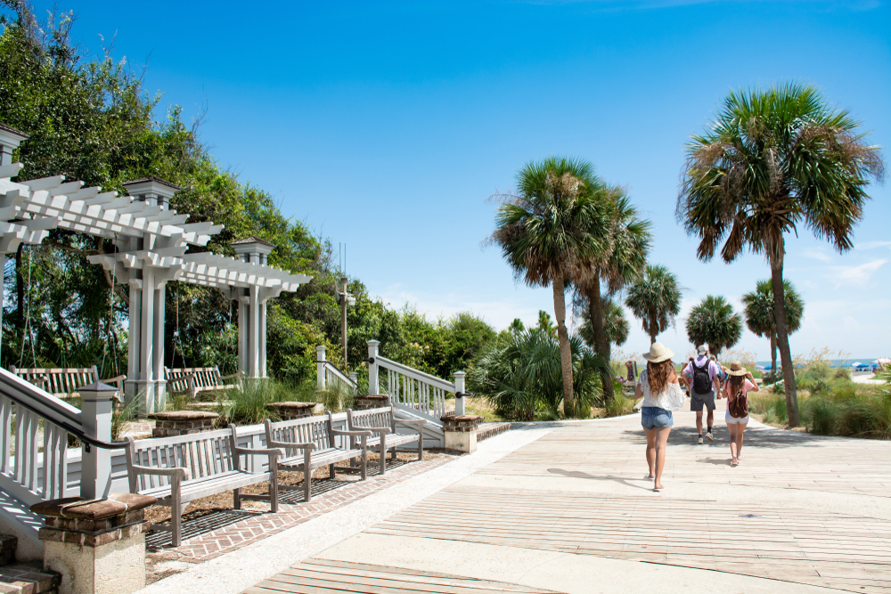 People walking on a pier surrounded by palm trees in Hilton Head.