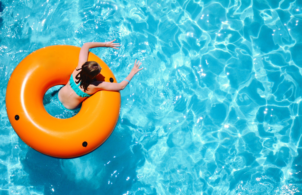Girl in an orange tube floating in the pool