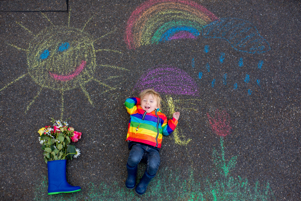 Kid laying down surrounded by chalk art