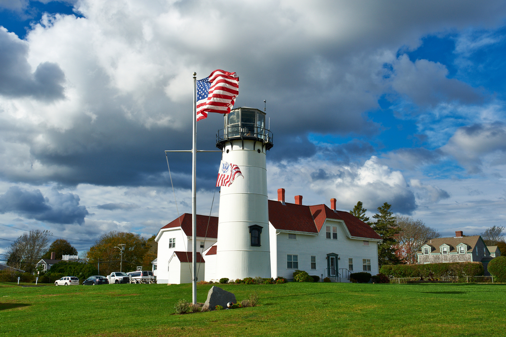 Black and white lighthouse by a USA flag